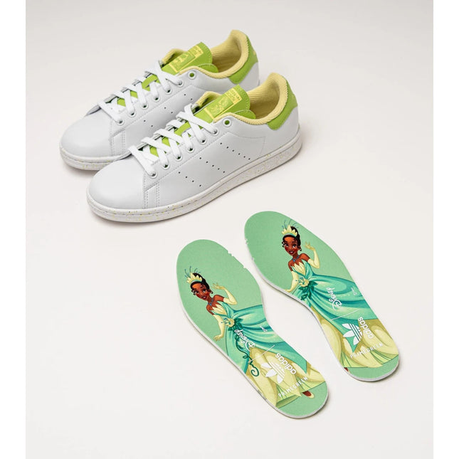 Adidas Stan Smith Disney Tiana and the Frog limited edition women's sneakers, featuring a classic white upper with green accents, comfortable lightweight cushioning, and a sustainable sole made from recycled materials. PlatiNum