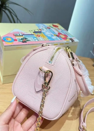 Mini borsa in pelle martellata rosa chiaro con cuciture trapuntate, chiusura con cerniera a lucchetto e tracolla rimovibile con catena dorata.