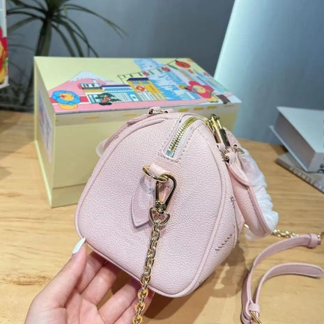 Mini borsa in pelle martellata rosa chiaro con cuciture trapuntate, chiusura con cerniera a lucchetto e tracolla rimovibile con catena dorata.