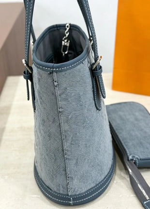 Borsa a secchiello mini in denim blu con finiture in pelle scura, tracolla regolabile, dotata di portamonete staccabile.