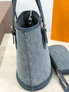 Borsa a secchiello mini in denim blu con finiture in pelle scura, tracolla regolabile, dotata di portamonete staccabile.