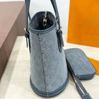 Borsa a secchiello mini in denim blu con finiture in pelle scura, tracolla regolabile, dotata di portamonete staccabile.