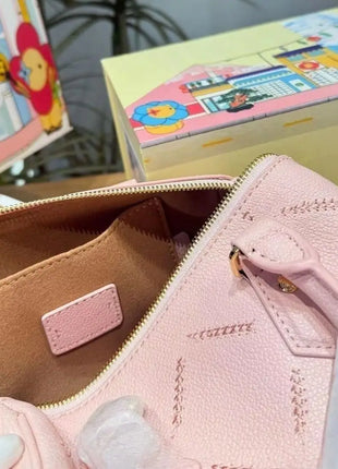 Mini borsa in pelle martellata rosa chiaro con cuciture trapuntate, chiusura con cerniera a lucchetto e tracolla rimovibile con catena dorata.
