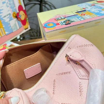 Mini borsa in pelle martellata rosa chiaro con cuciture trapuntate, chiusura con cerniera a lucchetto e tracolla rimovibile con catena dorata.