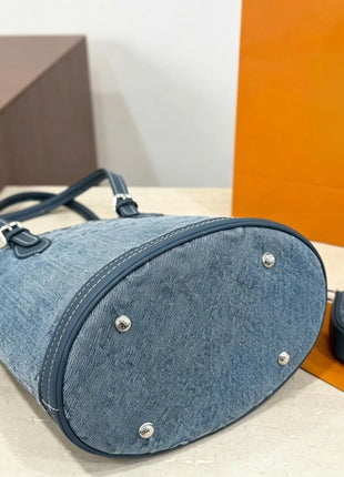 Borsa a secchiello mini in denim blu con finiture in pelle scura, tracolla regolabile, dotata di portamonete staccabile.