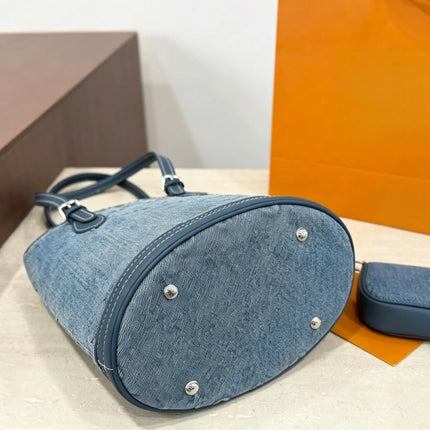 Borsa a secchiello mini in denim blu con finiture in pelle scura, tracolla regolabile, dotata di portamonete staccabile.