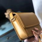 Borsa a tracolla in pelle liscia con patta, tracolla lunga sottile regolabile, borsa a tracolla rettangolare con dettagli di cuciture lunghe sotto il braccio.