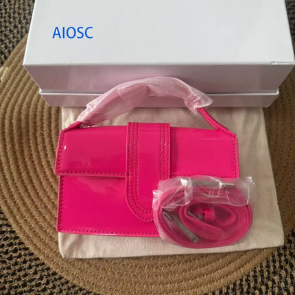Borsa piccola rettangolare in similpelle lucida retrò per donna, con cinturino decorativo centrale, trasformabile in borsa a tracolla.
