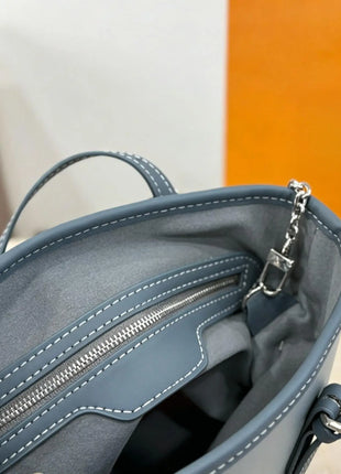 Borsa a secchiello mini in denim blu con finiture in pelle scura, tracolla regolabile, dotata di portamonete staccabile.