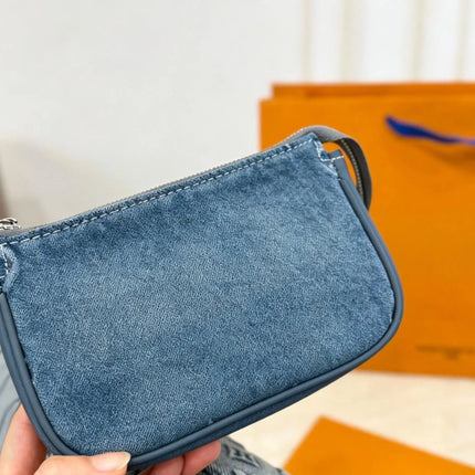 Borsa a secchiello mini in denim blu con finiture in pelle scura, tracolla regolabile, dotata di portamonete staccabile.