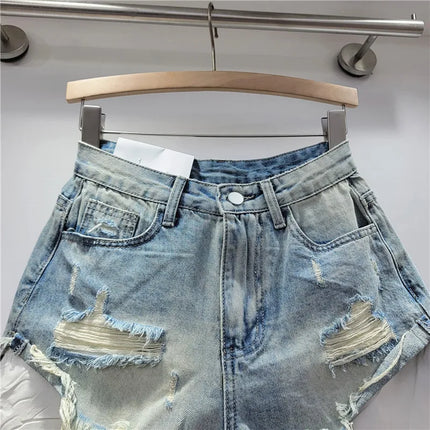 Pantaloncini di jeans con foro rosa delle nuove donne estive 2026 a vita alta che dimagriscono pantaloncini con bordo sfilacciato a trapezio per ragazza piccante