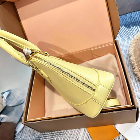 Borsa a mano in morbida pelle di vitello gialla, con chiusura color oro, manico superiore, tracolla staccabile abbinata, piccola borsa a spalla a forma di conchiglia.